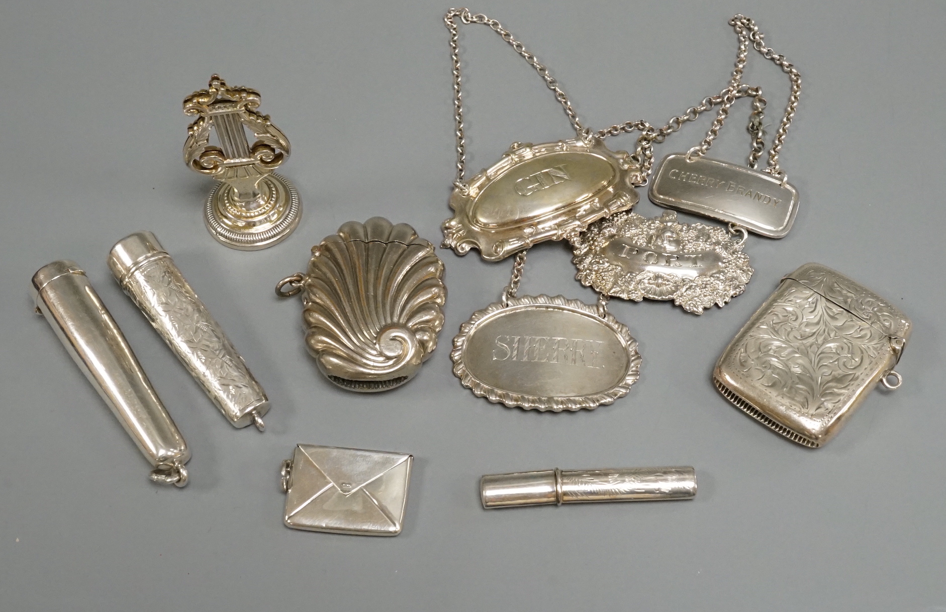 Two silver wine labels including 19th century, silver vesta case, silver cheroot holder, silver lyre menu holder and other items.